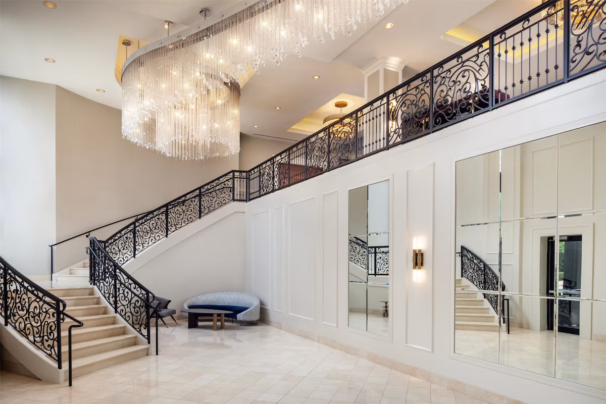 Grand hotel lobby with a sweeping staircase and crystal chandelier